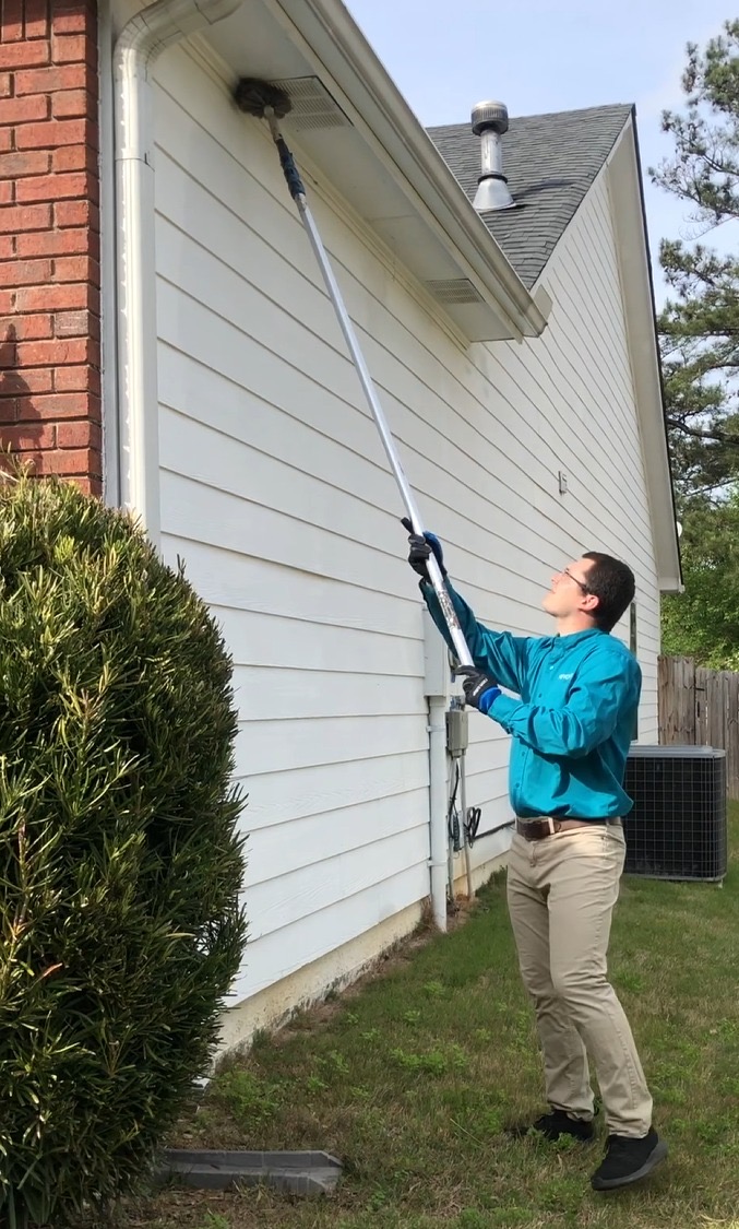 Nuvolve technician treating eaves and soffits with an extension pole